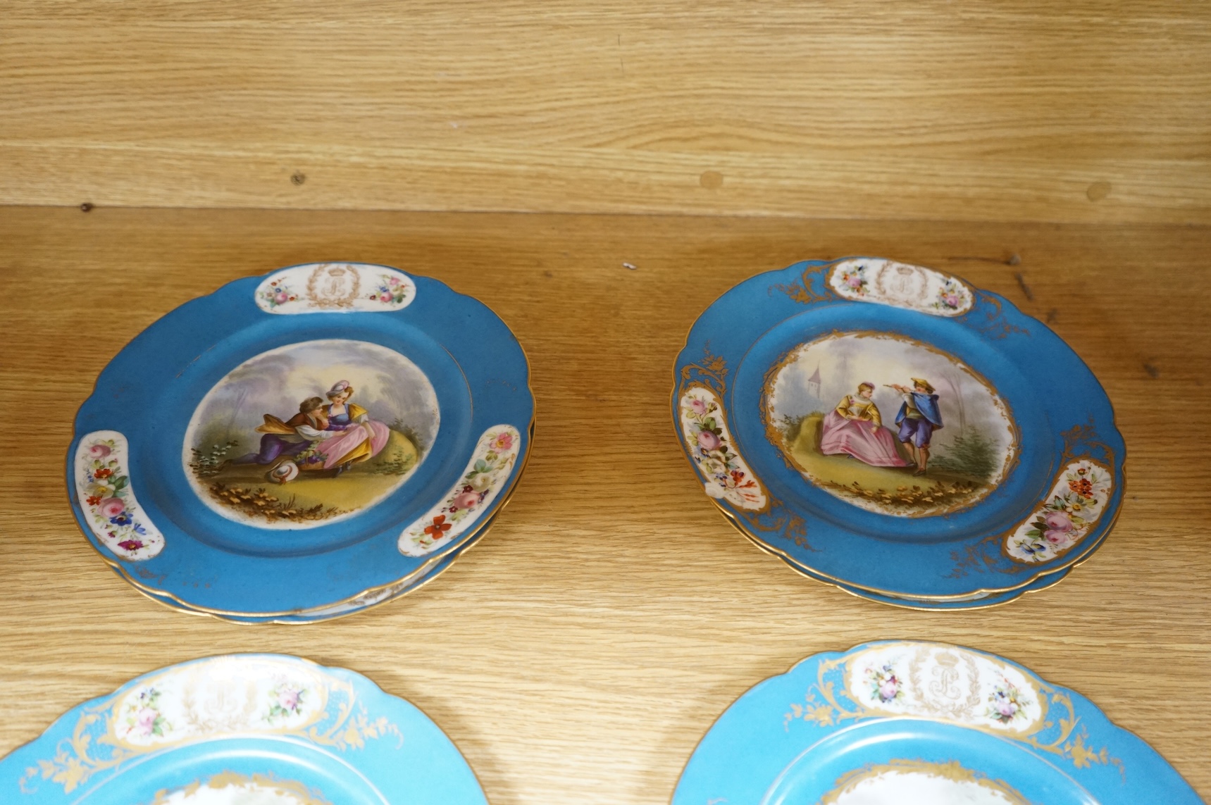 A set of eight 19th century Sevres style bleu celeste ground cabinet plates, each painted with a courting couple, 22cm diameter